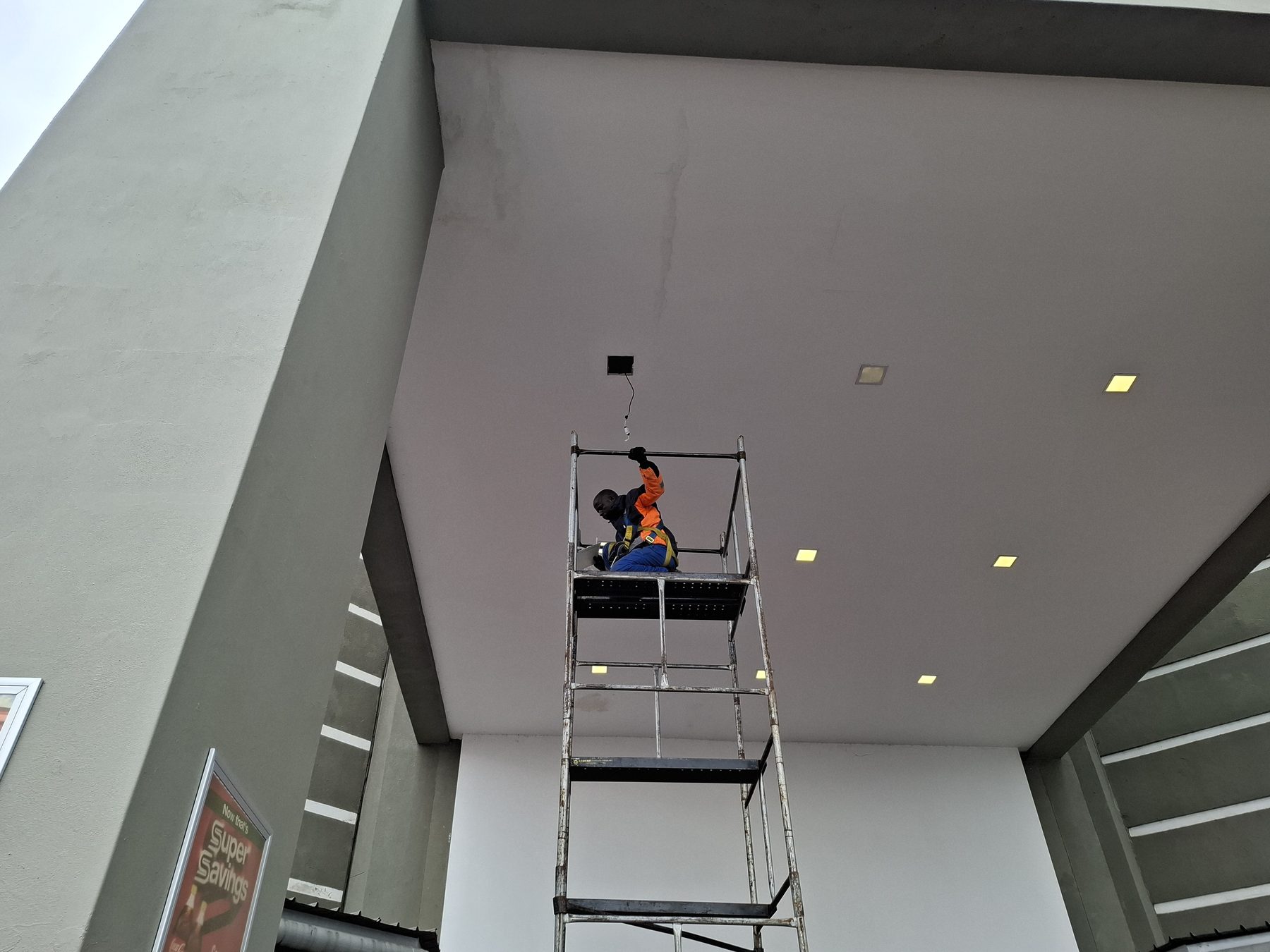 Open ceiling aperture with wiring exposed after removing the failed fitting