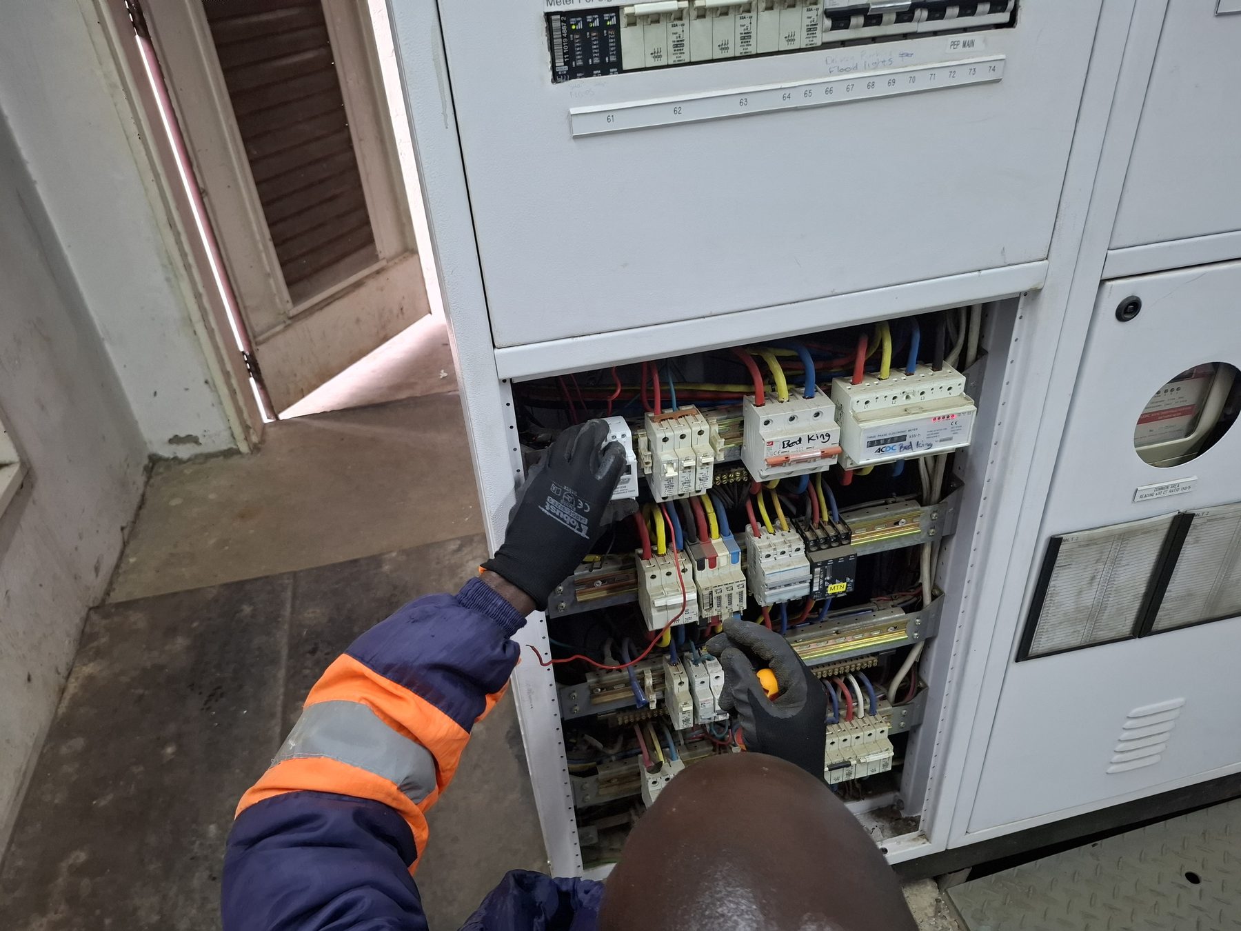 Technician working inside distribution board