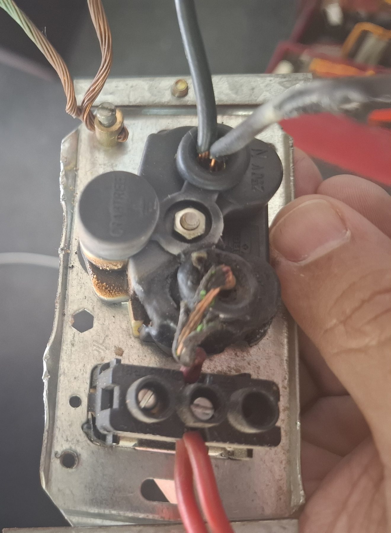 Close-up of a scorched terminal block with discoloured, corroded copper conductors