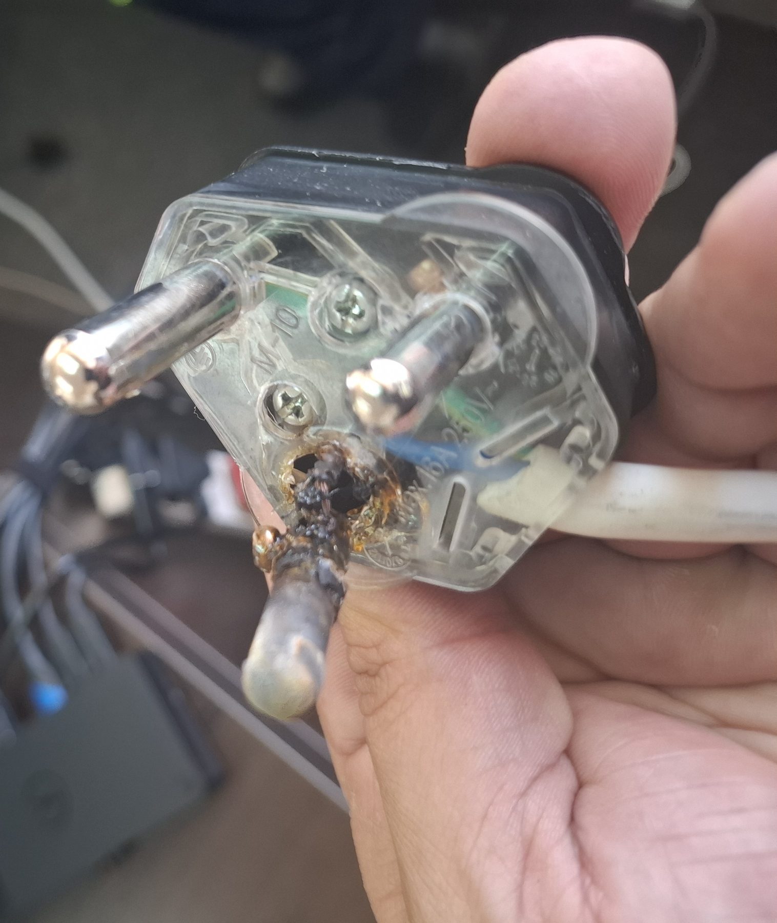 Burnt and melted plug top removed from a multi-plug adaptor after overload