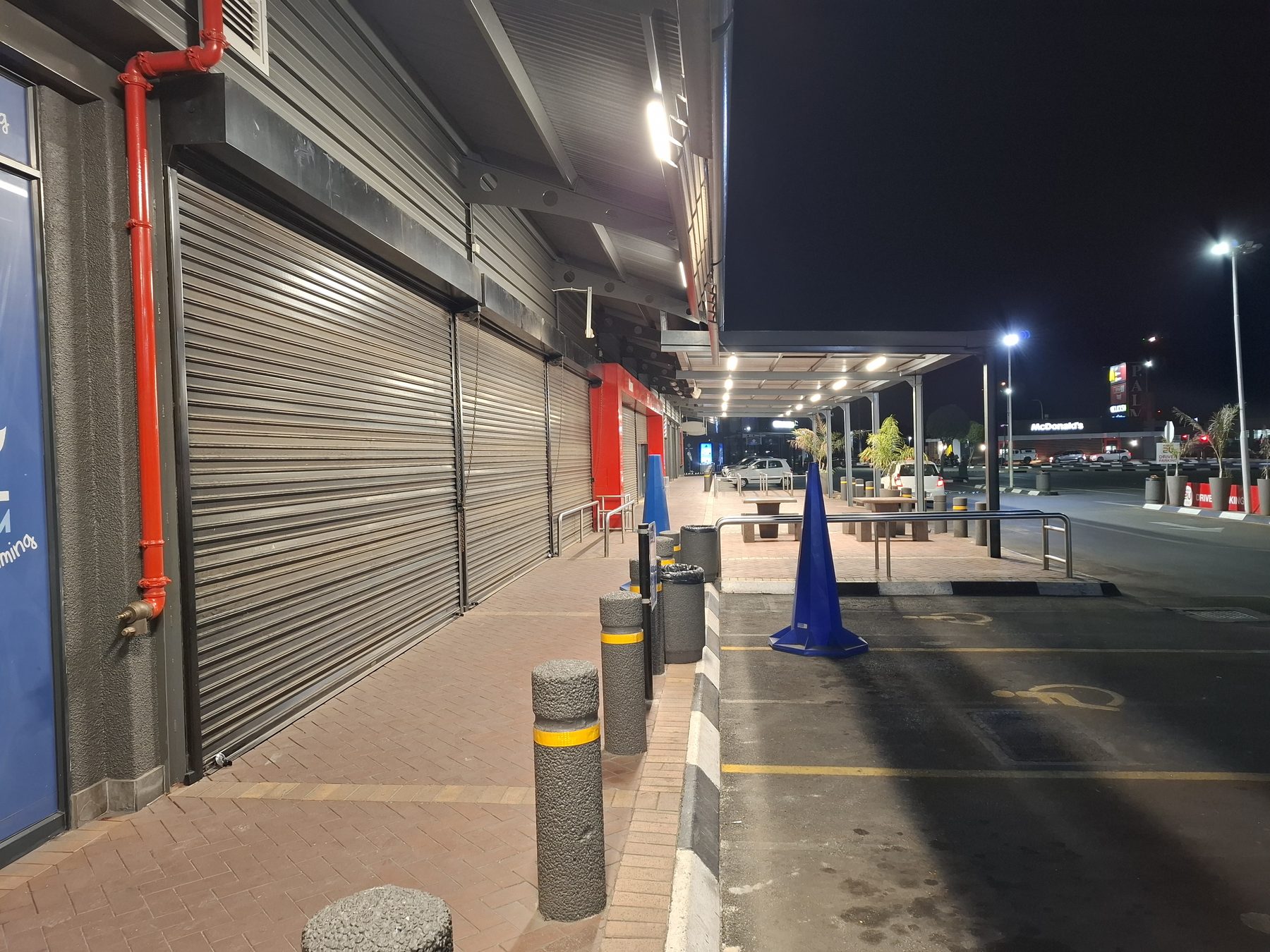 Storefront walkway and bollards under new canopy lighting
