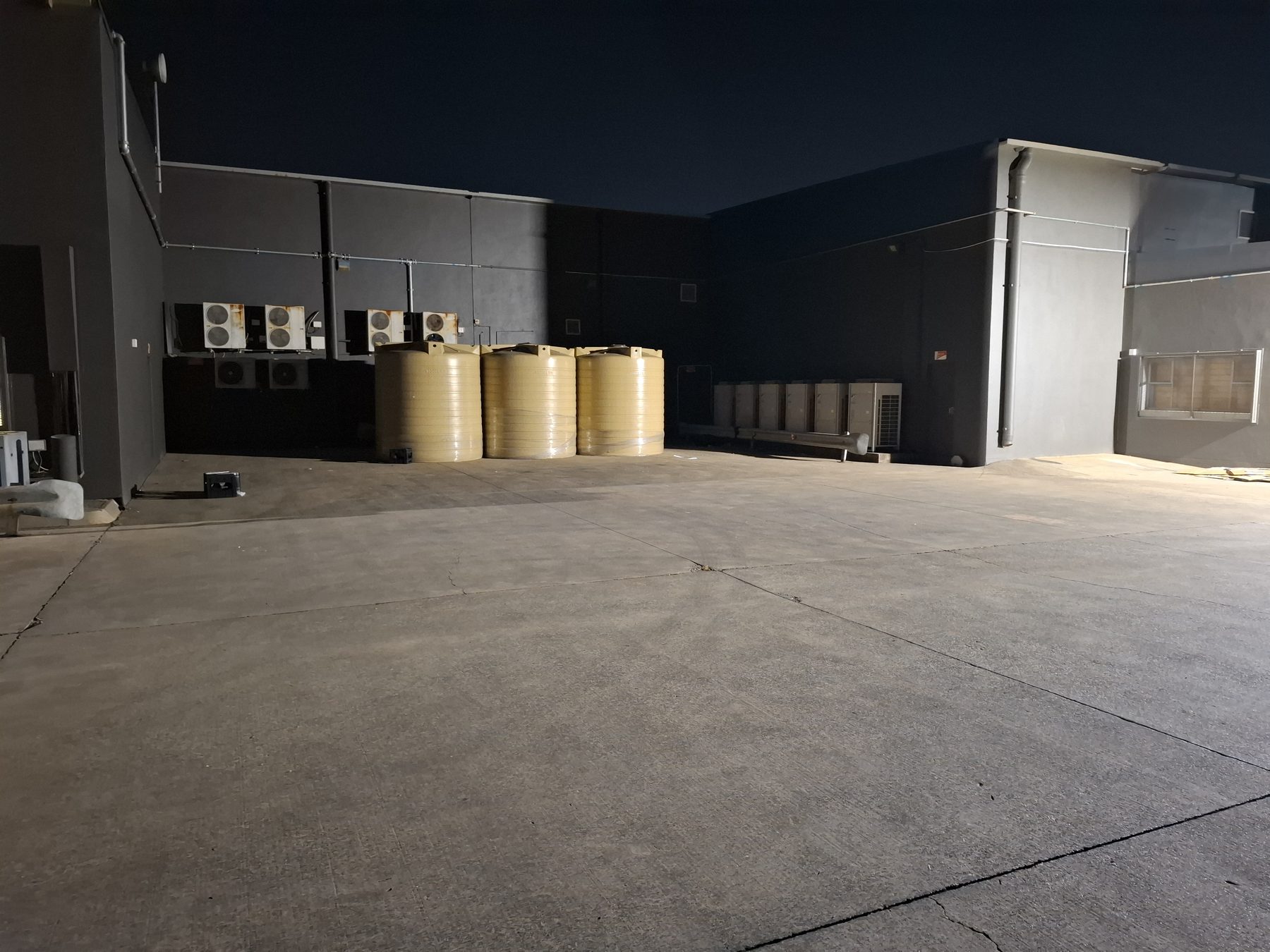 Back-of-house yard with water tanks, lit at night